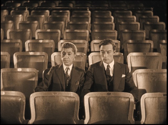 Buster and his valet, played by Snitz Edwards, sit stunned in Olympic Auditorium, after the formerly obscure boxer who shares Keaton’s name has unexpectedly become champion.