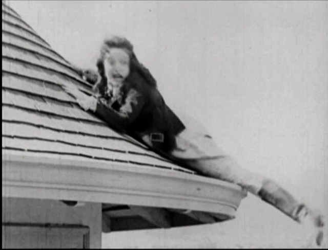 Mable Normand clings to the roof of the Castle Towers Apartment in Mickey.